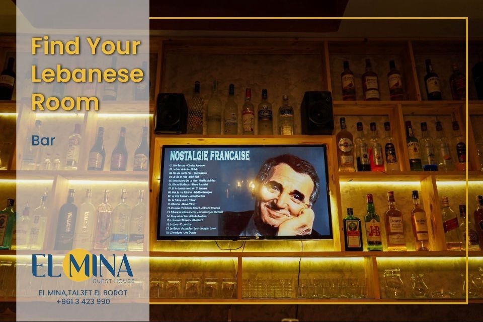 Bar interior with shelves of liquor bottles and a screen showing music playlist, featuring a man's photo.